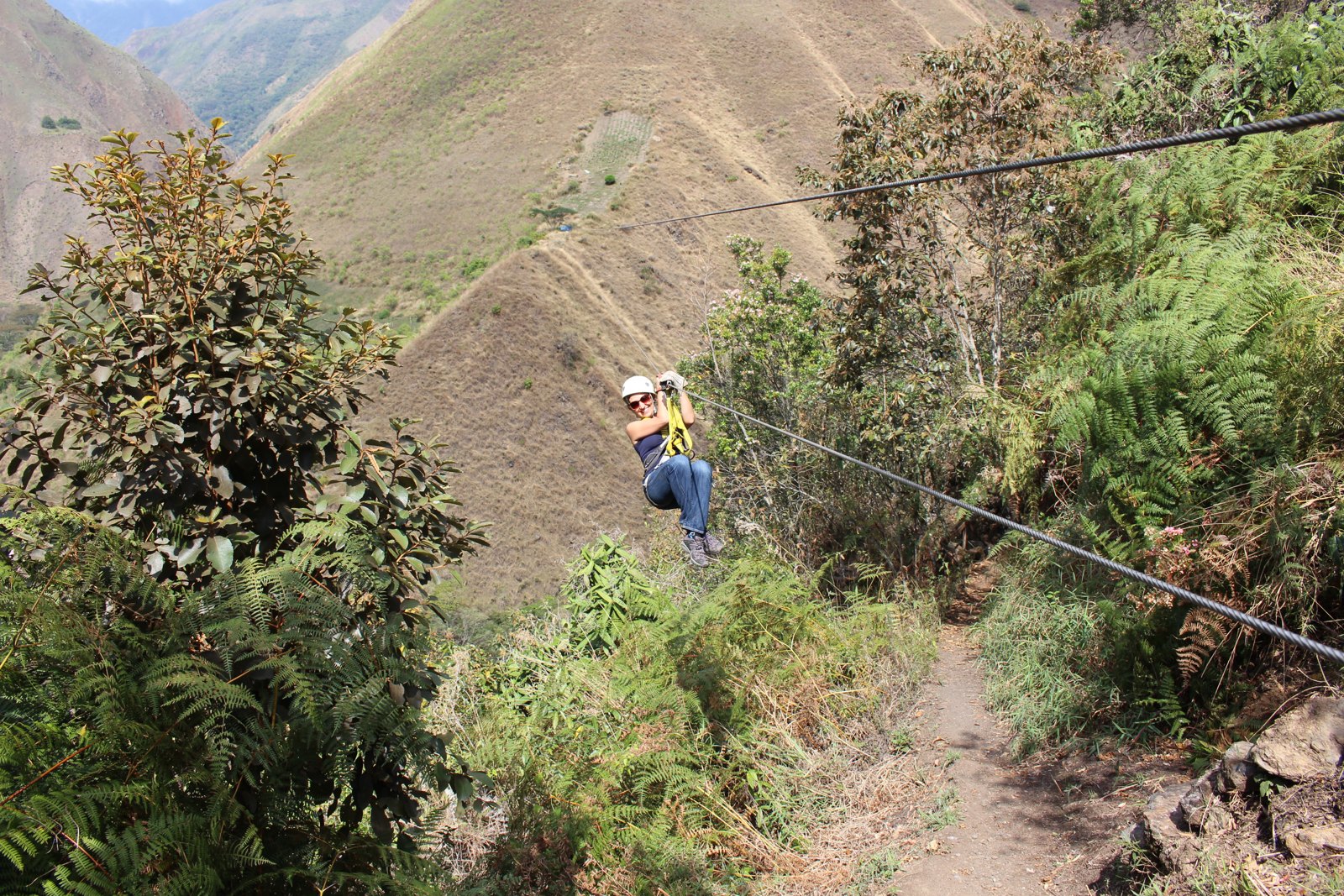 Slavica on a zipline in a mountainous landscape