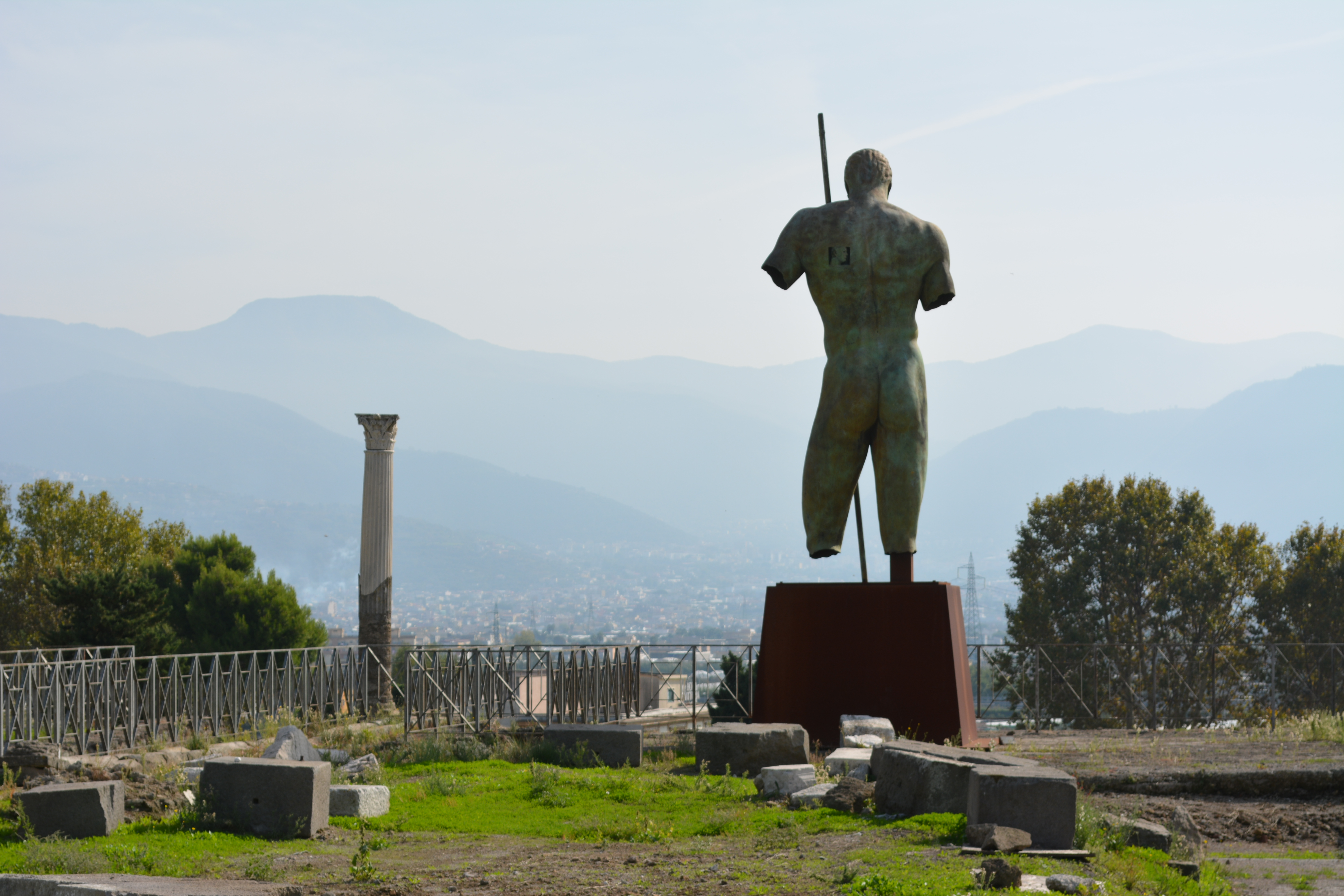 Ancient bronze statue overlooking a mountainous landscape