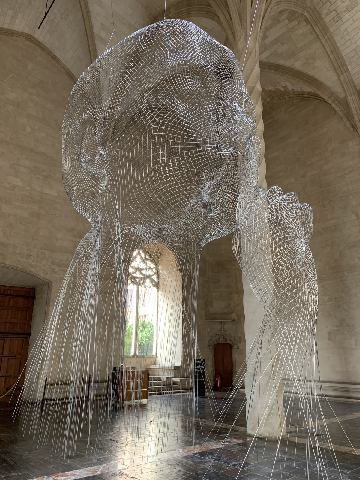 Vaulted stone interior with a delicate suspended installation